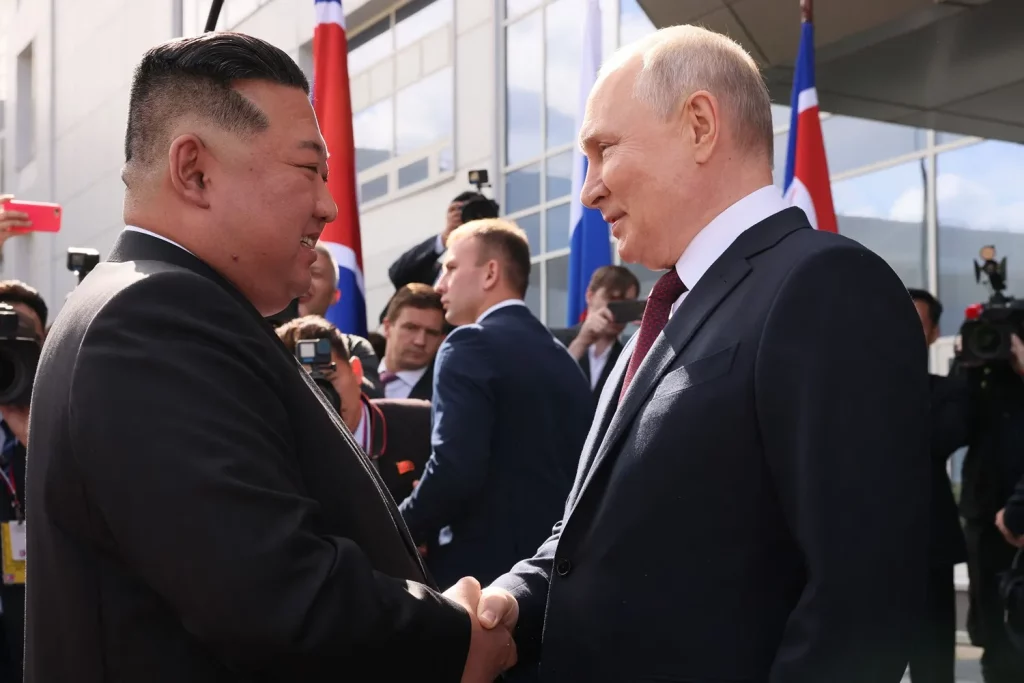 Vladimir Poutine et Kim Jong-un se serrant la main lors du sommet historique, symbolisant une nouvelle page de coopération entre la Russie et la Corée du Nord.